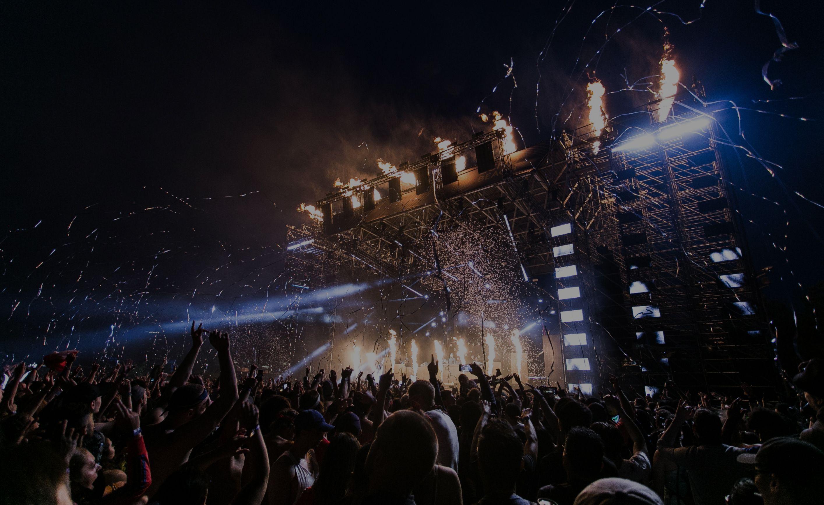 A festival crowd under stage lights, on a ticket shop’s page